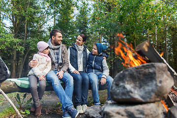 Image showing happy family sitting on bench at camp fire