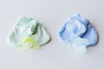 Image showing close up of baby mittens and soothers for twins