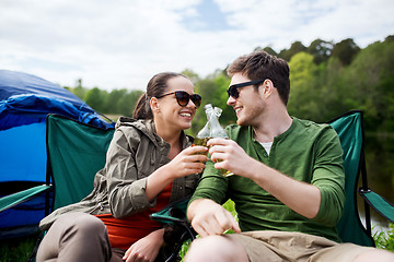 Image showing happy couple clinking drinks at campsite tent