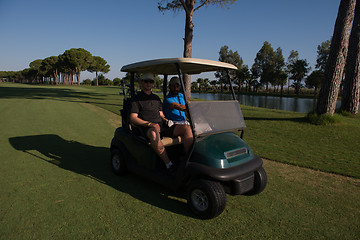 Image showing golf players driving cart at course