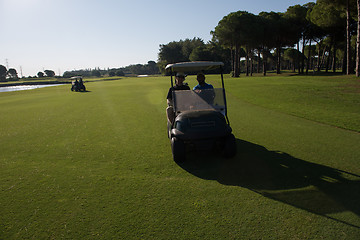 Image showing golf players driving cart at course