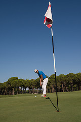 Image showing golf player hitting shot at sunny day