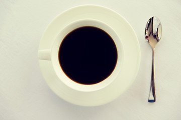 Image showing cup of black coffee with spoon and saucer on table