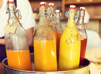 Image showing bottles of juice in ice bucket at market