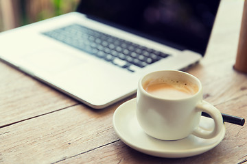 Image showing close up of laptop and coffee cup on office table