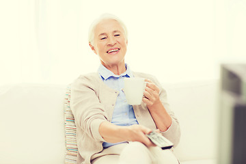 Image showing senior woman watching tv and drinking tea at home