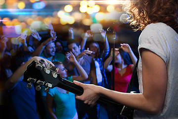 Image showing female singer playing guitar over happy fans crowd