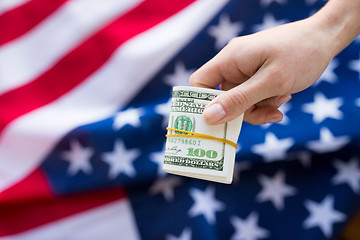 Image showing close up of hand with money over american flag