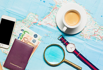 Image showing Preparation for travel concept - map, magnifying glass, cup of coffee, notepad, phone