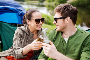 Image showing happy couple clinking drinks at campsite tent
