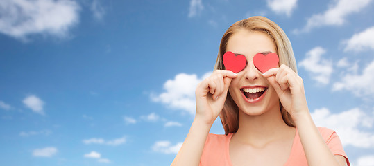 Image showing happy young woman with red heart shapes on eyes