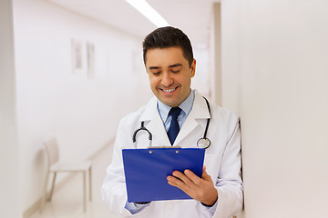 Image showing happy doctor writing to clipboard at hospital