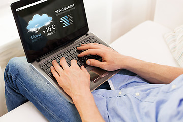 Image showing close up of man typing on laptop computer at home