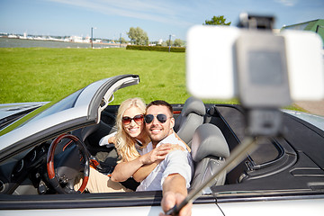 Image showing happy couple in car taking selfie with smartphone