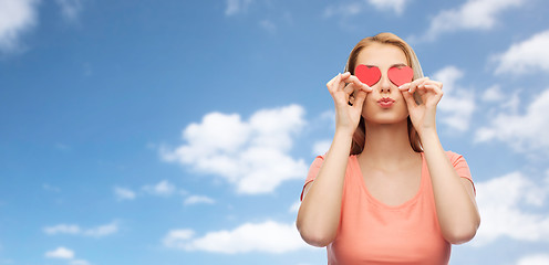 Image showing happy young woman with red heart shapes on eyes