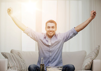 Image showing smiling man watching sports at home