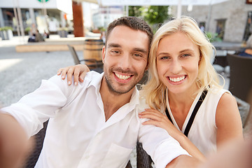 Image showing happy couple taking selfie at restaurant terrace