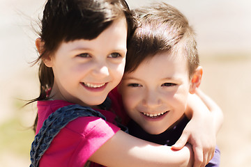 Image showing two happy kids hugging outdoors