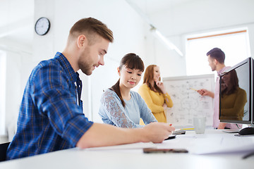 Image showing creative team with blueprint at office