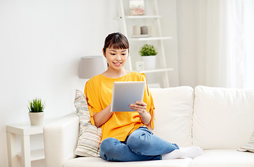 Image showing happy young asian woman with tablet pc at home