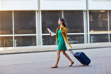 Image showing happy young woman with travel bag and map in city