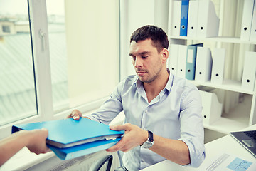 Image showing businessman taking folder from secretary in office