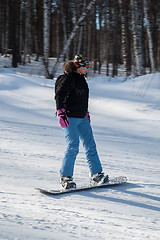 Image showing Woman doing exercise on snowboard in sunny day