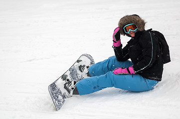 Image showing Woman with snowboard rests on snow