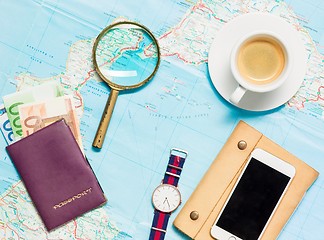 Image showing Preparation for travel concept - map, magnifying glass, cup of coffee, notepad, phone