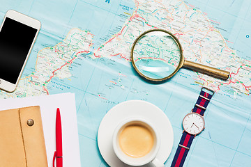 Image showing Preparation for travel concept - map, magnifying glass, cup of coffee, notepad, phone