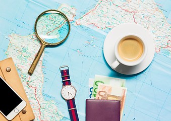 Image showing Preparation for travel concept - map, magnifying glass, cup of coffee, notepad, phone