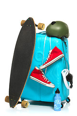 Image showing The blue suitcase, sneakers, skateboard on white background.