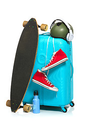 Image showing The blue suitcase, sneakers, skateboard on white background.