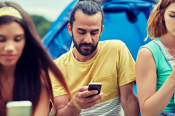 Image showing friends with smartphone and tent at camping