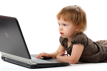 Image showing Small girl lieing and learning at notebook