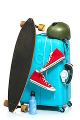 Image showing The blue suitcase, sneakers, skateboard on white background.