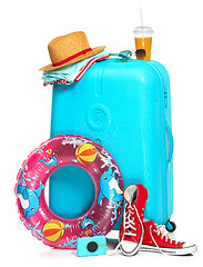 Image showing The blue suitcase, sneakers, hat and rubber ring on white background.