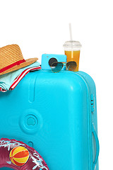 Image showing The blue suitcase, sneakers, hat and rubber ring on white background.