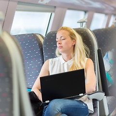 Image showing Woman sleeping while travelling by train.