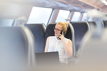 Image showing Business woman working while travelling by train.