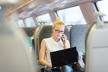 Image showing Business woman working while travelling by train.