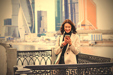 Image showing smiling beautiful middle-aged woman with a smartphone