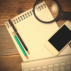 Image showing smartphone, computer keyboard, notebook, pen and magnifying glas