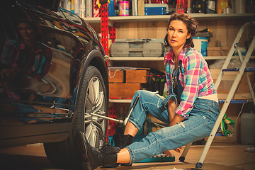 Image showing woman mechanic prepares a car for a travel