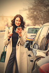 Image showing smiling middle aged brunette with smartphone