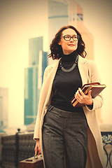 Image showing brunette with a wooden case and books in their hands