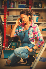 Image showing beautiful woman mechanic talking on mobile phone