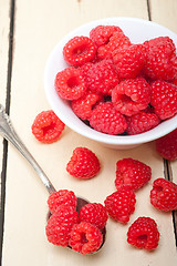 Image showing bunch of fresh raspberry on a bowl and white table