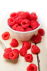 Image showing bunch of fresh raspberry on a bowl and white table