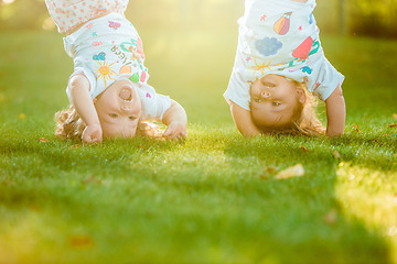 Image showing The two little baby girls hanging upside down